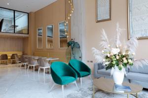 a lobby with a couch and chairs and tables at Hotel City Bog Corferias in Bogotá