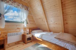 1 dormitorio en una cabaña de madera con cama y ventana en Woodland, en Žabljak