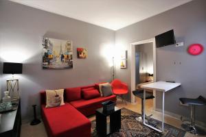a living room with a red couch and a table at GK Athens by GK Hospitality Group in Athens
