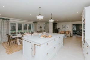 a large white kitchen with a large island in the middle at Hayward House, Hot Tub, Large Garden in Henley on Thames