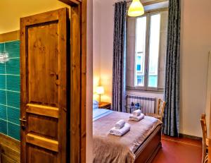 a bedroom with a bed with a wooden door and a window at Guest House Lorvand in Rome