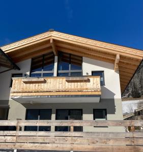 ein Haus mit einem Holzbalkon darüber in der Unterkunft Appartement Katrin in Bramberg am Wildkogel