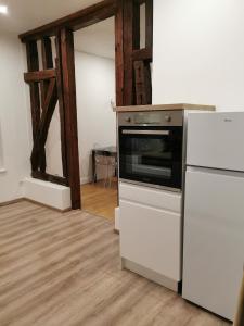 een keuken met een fornuis en een witte koelkast bij Ô Cœur de Troyes - Bulles & Spa 4 étoiles in Troyes