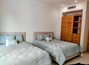 Un pat sau paturi într-o cameră la Bliss at Puerto Aventuras