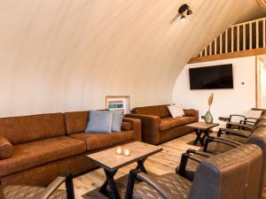 een woonkamer met banken, tafels en stoelen bij Nice group accommodation with BBQ in Overijssel in De Bult