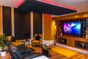 a living room with a couch and a tv at Optimal Apartments in Bradford