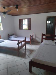 a room with two beds and two windows at Guesthouse da Barra in Florianópolis