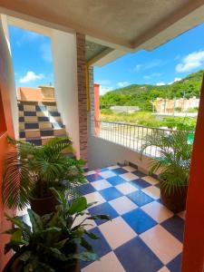 a balcony with potted plants and a large window at Hotel Frailes in Arriaga