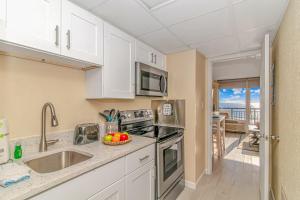 een keuken met een wastafel en een fornuis top oven bij Oceanfront 1 Bedroom 2 Bath Suite Boardwalk 439 in Myrtle Beach