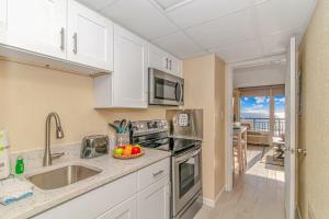 a kitchen with a sink and a stove top oven at Oceanfront 1 Bedroom 2 Bath Suite Boardwalk 439 in Myrtle Beach