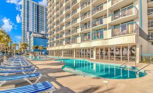 een hotel met ligstoelen en een zwembad bij Oceanfront 1 Bedroom 2 Bath Suite Boardwalk 439 in Myrtle Beach