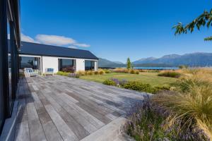 una terraza con vistas a una casa en Lake House - Te Anau Holiday Home, en Te Anau