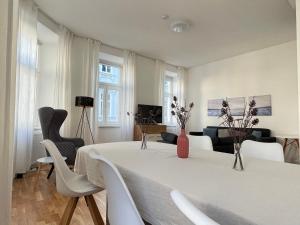 - un salon avec une table et des chaises blanches dans l'établissement BIG Apartment Vienna, à Vienne