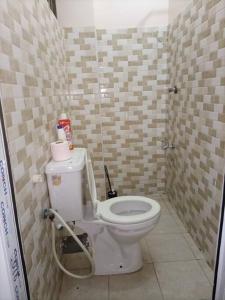 a bathroom with a white toilet in a room at Cosy studio Yellow House bamburi in Mombasa