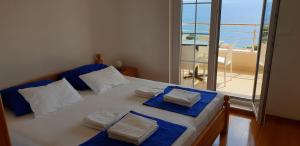 een slaapkamer met een bed en uitzicht op de oceaan bij Apartments KARLO in Baška Voda