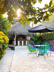 eine Terrasse mit Stühlen und einem Tisch mit einem Sonnenschirm in der Unterkunft Hotel Costa Coral in Tambor