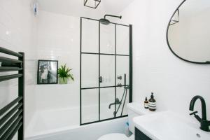 a bathroom with a shower and a toilet and a sink at Modern Garden Apartment Camden in London