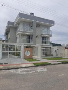 APARTAMENTO ENCANTADOR, À 400 METROS DA PRAIA DE PALMAS, في جوفيرنادور سيلسو راموس: مبنى أبيض كبير عليه ساعة