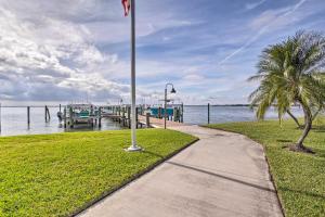 a sidewalk next to a dock with a flag at Jensen Beach Home with Pool Access Less Than 1 Mi to Beach! in Jensen Beach