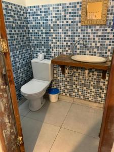 a bathroom with a toilet and a sink at Recanto das Margaridas in Ilhabela