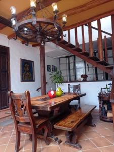 a dining room with a wooden table and a chandelier at AQUI ESTOY BIEN in Barichara