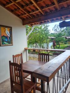 a wooden table and chairs on a balcony at Pousada e Restaurante Clima da Serra in Cunha