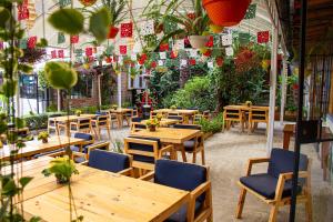 a restaurant with wooden tables and chairs and plants at Rukka Lodge in Tumbaco