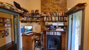 a room with a fireplace and book shelves with books at No14 Lovel St in Katoomba