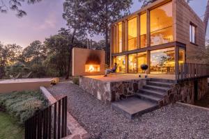 una casa con chimenea en el patio trasero en Cabaña de lujo moderna con Alberca climatizada Mazamitla bosque 1, en Mazamitla