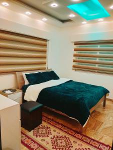 a bedroom with a large bed and a blue ceiling at Maria Home in Madaba