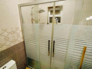 a shower with a glass door in a bathroom at Maria Home in Madaba