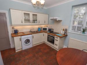 a kitchen with white cabinets and a table in it at Ashfield Studio in Usselby