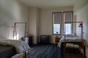 1 dormitorio con 2 camas y 2 ventanas en Crested Butte Hostel, en Crested Butte