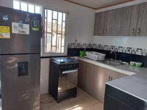 a kitchen with a stainless steel refrigerator and a sink at Posada Sorybego in San Andrés