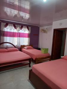 Cette chambre comprend 3 lits avec des draps rouges. dans l'établissement Posada Sorybego, à San Andrés