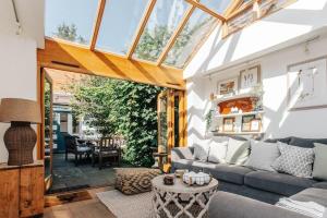 a conservatory living room with a couch and a table at Dolls House - Luxury Townhouse *sleeps 10* in Henley on Thames