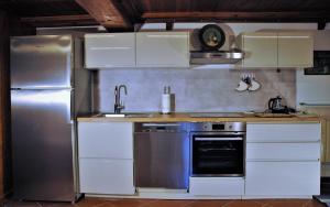 una cucina con frigorifero in acciaio inox e fornello di Villa Camilla - TINY - EXCLUSIVE POOL a Lucca