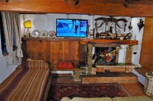 un soggiorno con camino e TV sopra di esso di Villa Camilla - TINY - EXCLUSIVE POOL a Lucca