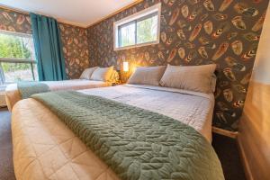 1 dormitorio con 1 cama grande en una habitación con papel pintado en The Springs Motel, en New Ashford
