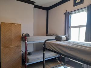 twee stapelbedden in een kamer met een raam bij Ozi Inn Backpackers - Perth -Valid International Passport Required in Perth
