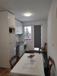 a kitchen with a table and chairs and a kitchen with a table and a table at Apartman MiMa in Pale