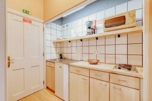 a kitchen with white cabinets and white appliances at ASPA - Alegria Studios in Funchal