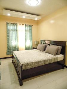 a bedroom with a large bed in front of a window at Casa Cecilia-Entire house located near 100 Islands in Alaminos