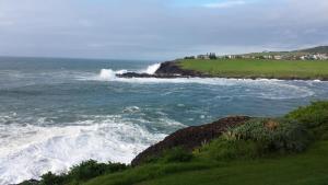 a view of the ocean with waves crashing on a cliff at Sea Whispers in Kiama