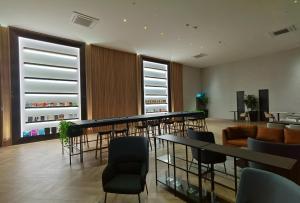 ein Wartezimmer mit Tischen, Stühlen und Fenstern in der Unterkunft Beacon Exec Suites# Msg Chair#Disney Hotstar in George Town