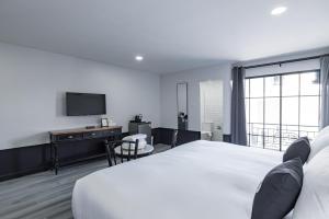 a hotel room with a bed and a television at Blu Monkey Boutique Bangsaen in Ban Hua Khao Sammuk