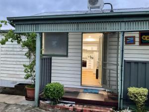 a small house with a door open on a porch at Hughesdale Private Studio in Oakleigh
