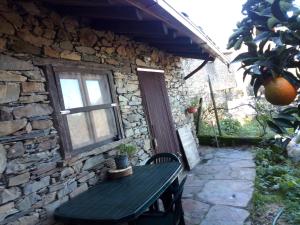 a stone house with a table and a window at Casa do Pastor in Lousã