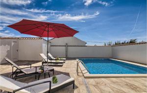 a patio with a red umbrella and a pool at Beautiful Home In Liznjan in Ližnjan +33 photos