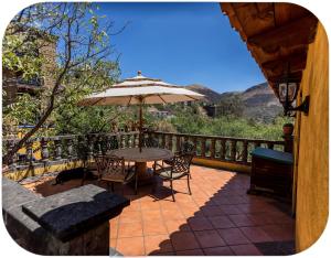 een patio met een tafel en stoelen en een parasol bij Depa Mellado - Zona turística Guanajuato in Guanajuato